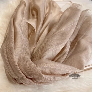 Close-up of champagne silk wool scarf featuring sparkling gold metallic pinstripe texture