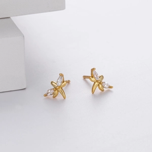 Macro shot of gold butterfly stud earrings featuring marquise cut zirconia stones
