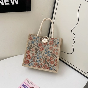 Detailed macro view of retro floral jute lunch bag with white woven rope handles and button