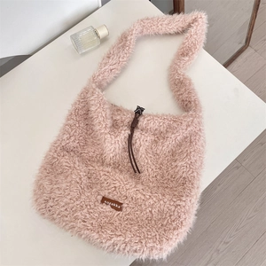 Detail shot of soft pink lamb wool tote bag with brown leather tag and drawstring closure