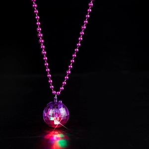 Close-up of a 70s retro disco ball necklace with colorful LED lights on a black base