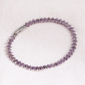 Macro view of purple marquise-cut cubic zirconia tennis bracelet on white fabric
