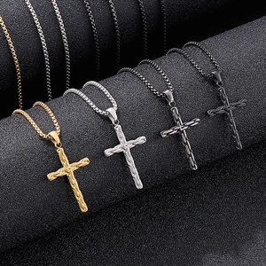 Dettaglio di ciondoli a croce nei colori oro, argento e nero con trama a catena