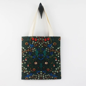 William Morris floral canvas tote bag in dark green hanging on a white wall