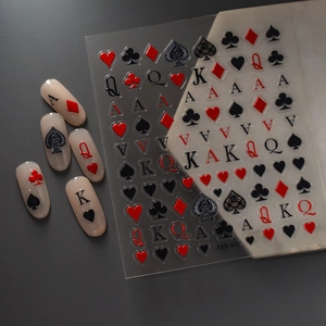 Macro shot of 5D embossed poker nail stickers featuring red and black spade and heart motifs