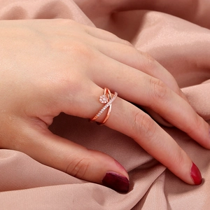 Rose gold adjustable ring with crisscross pave zircon on pink silk background