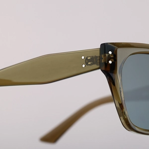 Detail of reinforced metal hinges and olive green frame on cat-eye polarized sunglasses