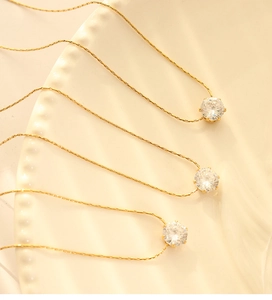 Detailed view of three 18K gold plated snake chain necklaces with zircon pendants