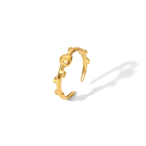 Dettaglio di anello dorato regolabile con design artistico a ramo organico