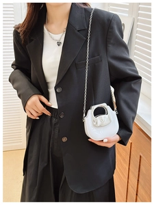 Chic mini white jelly crossbody bag with silver chain strap worn by a stylish model