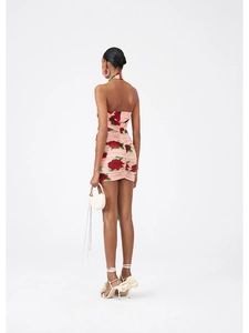 Detail of the back view of the pink floral halter dress with red roses and open back