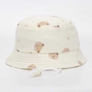 Détail d'un chapeau bob en coton crème avec imprimé ours et cordon ajustable
