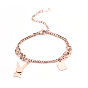 Close-up of rose gold stainless steel bracelet featuring a bunny charm and engraved tag