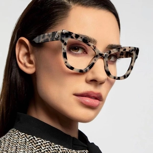 Close-up of tortoise shell cat-eye glasses frame with circular H logo on temples