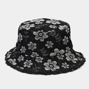 Detailed view of denim bucket hat with floral jacquard pattern and frayed raw edges