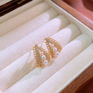 Detail of vintage gold fan earrings featuring white pearls and zircon on velvet pad