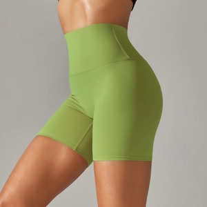 Detail of high-waisted grass green yoga shorts with seamless stretch fabric on female model