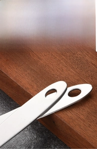Close-up of thick stainless steel spoon handle with hanging hole and brushed metal finish