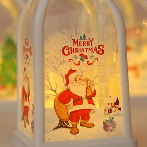 Close-up of white Christmas lantern with Santa Claus illustration and warm glowing light