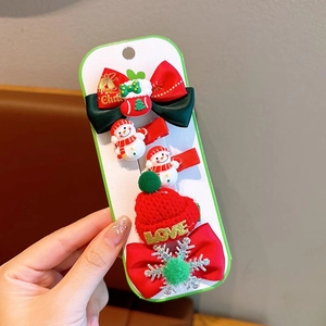 Detail of Christmas hair clip set featuring cute snowmen and red knitted hats on a card