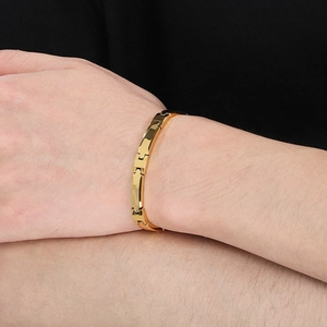 Detailed close-up of a gold-plated tungsten steel chain bracelet worn on a wrist