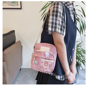 Sac bandoulière en toile rose avec appliques de lapin mignon porté par une femme