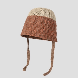 Primer plano de un sombrero de ganchillo bicolor hecho a mano con cintas y textura