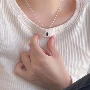 Elegant 925 sterling silver necklace featuring a black oval gemstone pendant on model