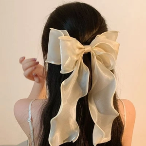 Elegant beige chiffon bow hair clip shown on the back of a model's head for a soft look