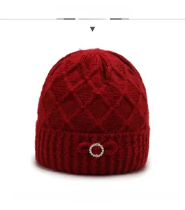 Front view of a warm dark red knit hat for elderly women with rhinestones and a bow