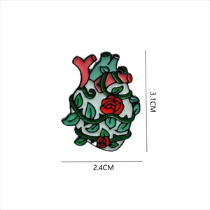 Detailed enamel heart brooch with green leaves and red roses measuring 3.1cm by 2.4cm