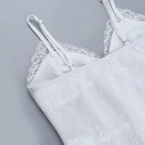 Close-up of white lace camisole showing floral pattern and adjustable shoulder strap detail