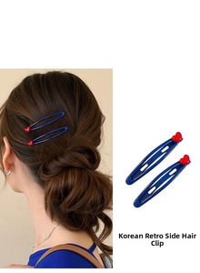Close-up of blue bow hair clips with red hearts shown on model and white background