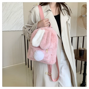 Detailed view of pink faux fur backpack featuring white bunny ears and a fluffy pom-pom