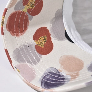 Close-up of artistic watercolor print and six-row parallel stitching on the cap brim