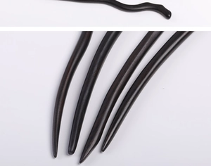 Macro detail of wave-shaped sandalwood hairpins showing smooth texture and wood grain