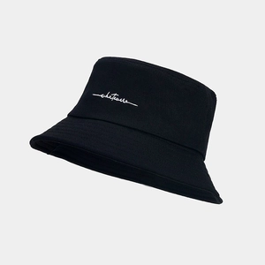 Close-up of white embroidered whatever text on black cotton canvas bucket hat