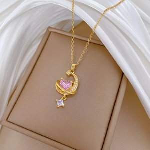 Elegant gold necklace featuring pink heart moon pendant and tassels on silk fabric