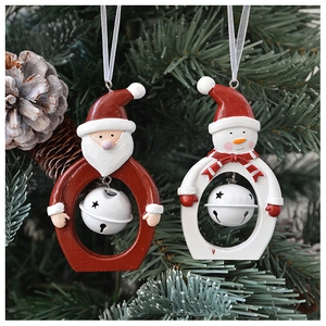 Detail of Santa and Snowman resin ornaments with white bells on green pine tree branches
