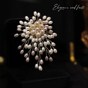 Macro shot of luxury pearl snowflake brooch with gold wire weaving on black box
