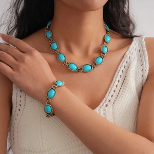 Close-up of turquoise oval necklace and bracelet set with retro gold braided edges
