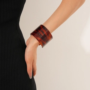 Detail of a wide leopard print acetate open bangle showing smooth texture and amber pattern