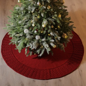 Red knitted Christmas tree skirt with festive woven patterns for holiday floor decoration