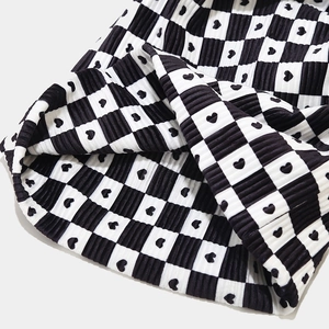 Classic black and white checkered knit hat with heart patterns and ribbed texture