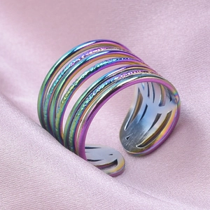 Vue macro d'une bague multicouche arc-en-ciel en acier sur un tissu en soie rose