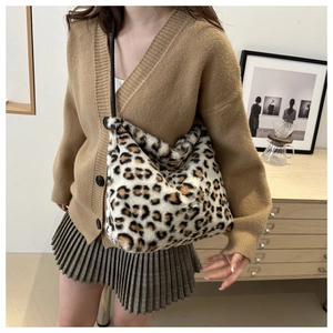 Model wearing a leopard print faux fur tote bag showing its capacity and soft texture