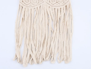 Detalle de falda bohemia de ganchillo beige con flecos delicados y diseño de punto calado