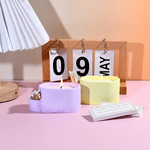 Detail of oval candle holder and match storage box in pastel lavender and yellow colors