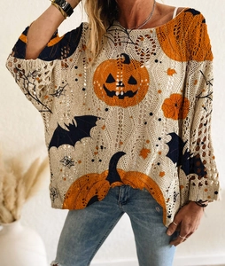 Détail de la maille ajourée avec imprimés festifs de citrouilles oranges et chauves-souris noires