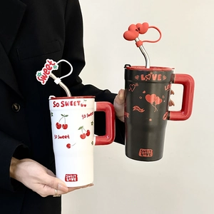 Detail of ceramic mugs with stainless steel straws and silicone cherry heart covers